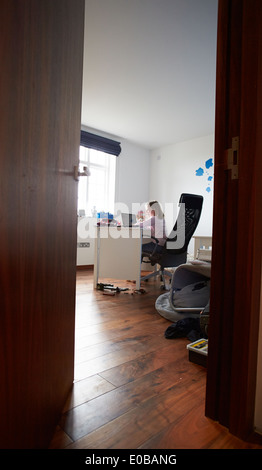 Girl Studying In Bedroom Using Laptop Stock Photo