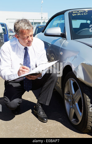 Loss Adjuster Inspecting Car Involved In Accident Stock Photo