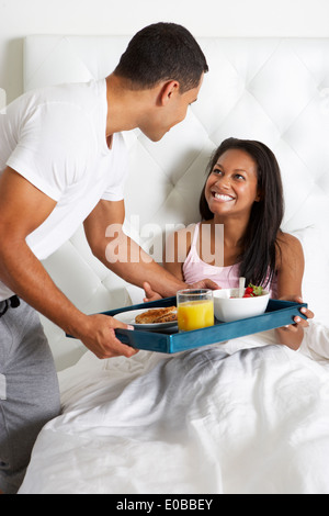 Man Bringing Woman Breakfast In Bed On Tray Stock Photo