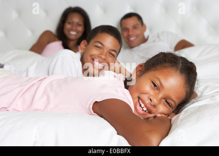 Family Relaxing In Bed Together Stock Photo