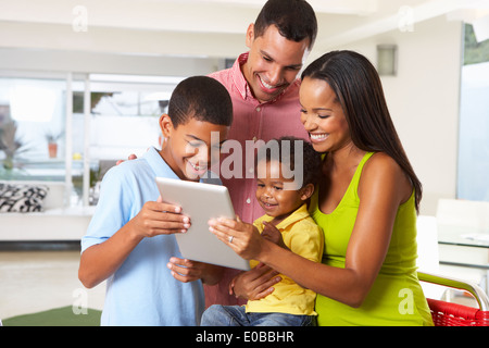 Family Using Digital Tablet In Kitchen Together Stock Photo