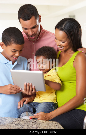 Family Using Digital Tablet In Kitchen Together Stock Photo