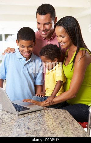 Family Using Laptop In Kitchen Together Stock Photo