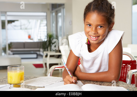 Girl Doing Homework In Kitchen Stock Photo