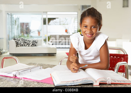 Girl Doing Homework In Kitchen Stock Photo
