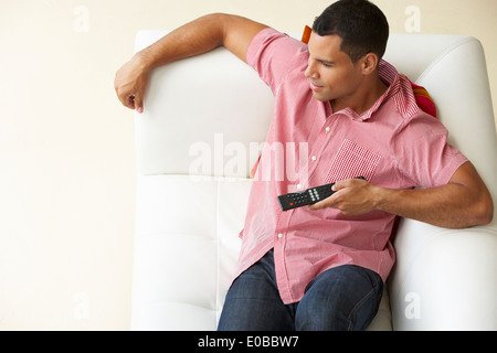 Overhead View Of Man Relaxing On Sofa Watching Television Stock Photo