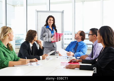 Businesswoman Conducting Meeting In Boardroom Stock Photo