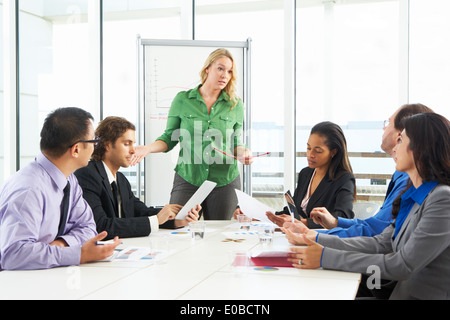 Businesswoman Conducting Meeting In Boardroom Stock Photo