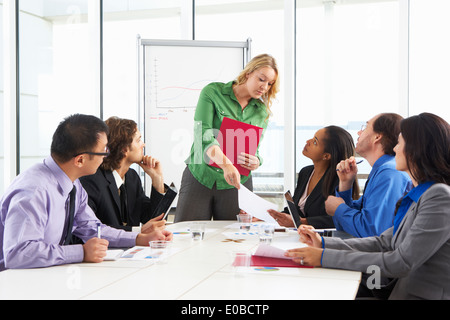 Businesswoman Conducting Meeting In Boardroom Stock Photo