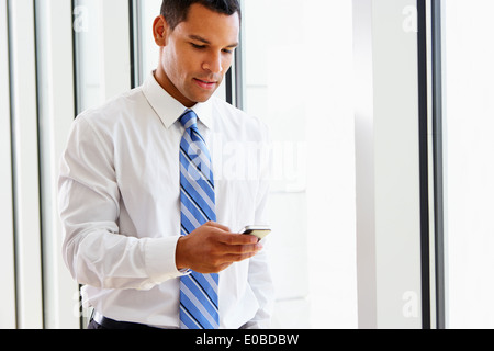 Businessman Using Mobile Phone In Office Stock Photo