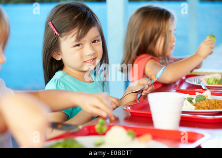 Elementary Pupils Enjoying Healthy Lunch In Cafeteria Stock Photo