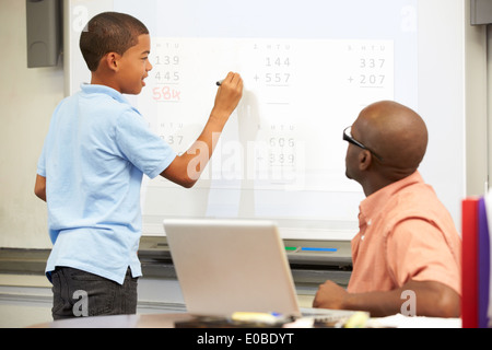 Male Student Writing Answer On Whiteboard Stock Photo