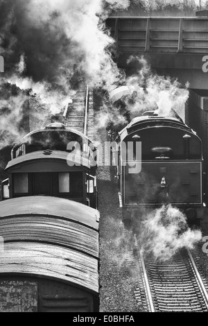 Black and white image looking down onto two steam trains as they pass on the Great Central Railway near Loughborough Stock Photo