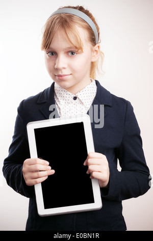 Little blond girl holds tablet device on white background Stock Photo