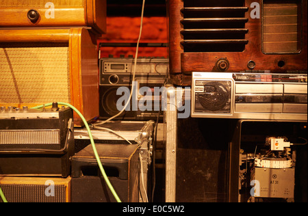 Tower - Stacks of Vintage Radios, stereo cassette deck, players and gramophone with red brick wall background Stock Photo