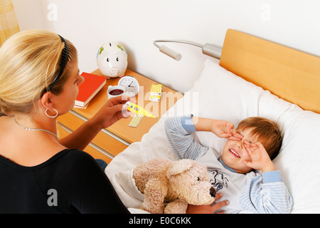 A mother and ill child in the bed. Influenza. Childhood illnesses., Eine Mutter und krankes Kind im Bett. Grippe. Kinderkrankhei Stock Photo