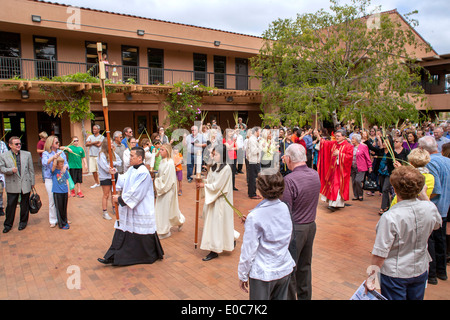 A Vietnamese seminarian intern holding a cross leads a procession to Palm Sunday mass  at St. Timothy's Catholic Church, Laguna Niguel. CA. Note palm fronds held by congregation and pastor in red. Stock Photo
