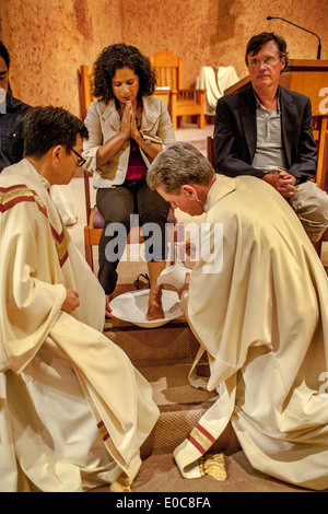 The robed pastor of St. Timothy's Catholic Church, Laguna Niguel, CA, washes the feet of parishioners on Holy Thursday mass in memory of Christ washing the feet of his disciples at the Last Supper. Note age range. Stock Photo