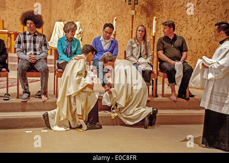 The robed pastor of St. Timothy's Catholic Church, Laguna Niguel, CA, washes the feet of parishioners on Holy Thursday mass in memory of Christ washing the feet of his disciples at the Last Supper. Note age range. Stock Photo