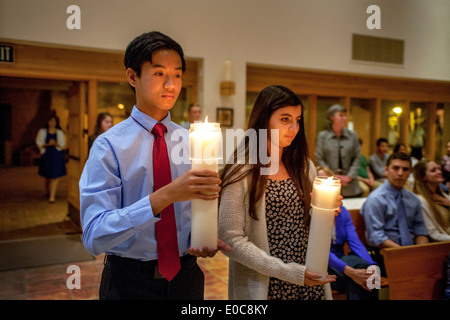 Carrying candles, young altar servers prepare to march down the aisle of St. Timothy's Catholic Church, Laguna Niguel, CA, at the beginning of Easter Vigil mass. Stock Photo