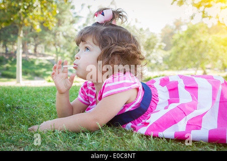 Cute Baby Girl Enjoying Her Lollipop Outdoors. Stock Photo