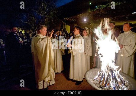 The robed pastor of St. Timothy's Catholic Church, Laguna Niguel, CA, reads from the gospel beside the Easter fire at the start of the Great Easter Vigil. Stock Photo