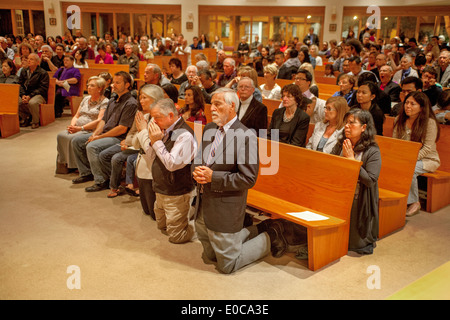 The congregation kneels in prayer during mass at St. Timothy's Catholic ...