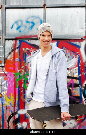 A cool looking youthful man before graffiti, Ein cool blickender Jugendlicher Mann vor Graffiti