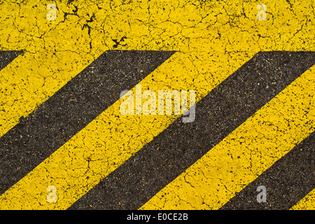 Yellow striped road markings on black asphalt highway. No parking is allowed on space covered with this stripes. Stock Photo