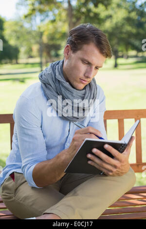 Stylish young man writing in his notepad Stock Photo