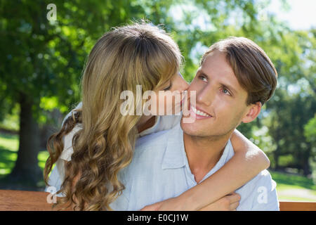 Affectionate couple relaxing on park bench together Stock Photo