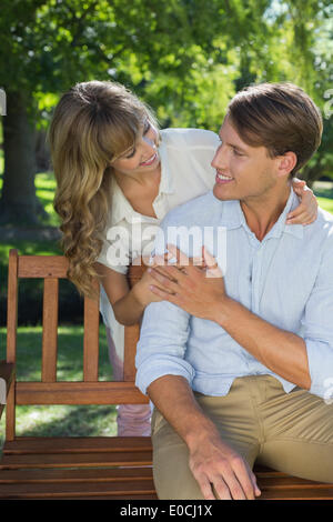 Affectionate couple relaxing on park bench together Stock Photo
