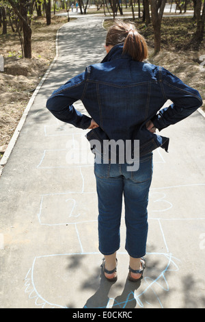 girl stay in base of hopscotch game outdoors Stock Photo