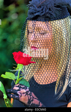 A young, mourning widow with veil and rose Stock Photo