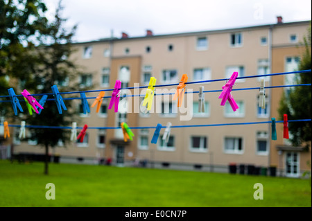 Many coloured clothes pegs on a clothesline. Living in the town Stock Photo
