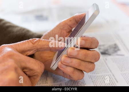 Female mature writing cell phone indoors closeup Stock Photo