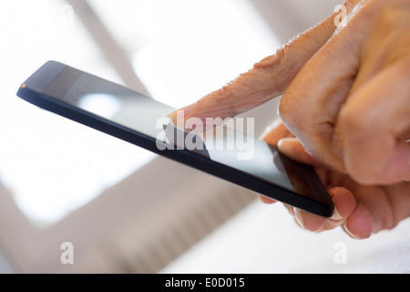 Female mature writing cell phone indoors closeup Stock Photo