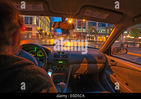 Male sitting in car at night with city lights-Victoria, British Columbia, Canada. Stock Photo