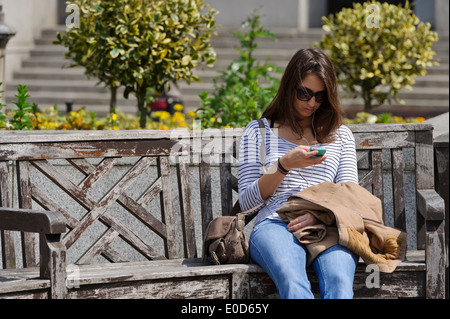 A young woman texting on moblie telephone, London, England, United Kingdom. Stock Photo