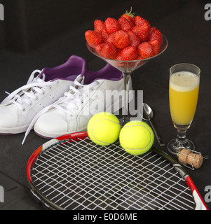 Tennis equipment and strawberries with a glass of Bucks fizz Stock Photo