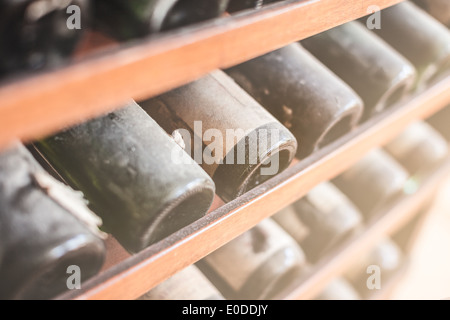 a lot of very old dusty wine bottles in an italian cellar Stock Photo