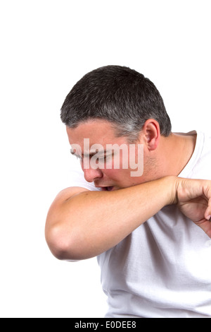 Sick adult male coughs inside his elbow to prevent the spread of germs. Stock Photo