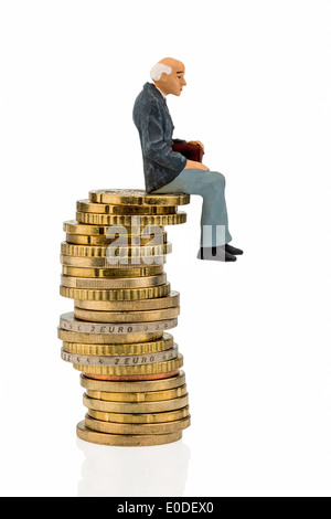 A pensioner sits on a coin pile. Symbolic photo for pension and Penison, Ein Rentner sitzt auf einem Muenzstapel. Symbolfoto fue Stock Photo