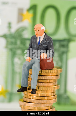 A pensioner sits on a coin pile. Symbolic photo for pension and Penison, Ein Rentner sitzt auf einem Muenzstapel. Symbolfoto fue Stock Photo