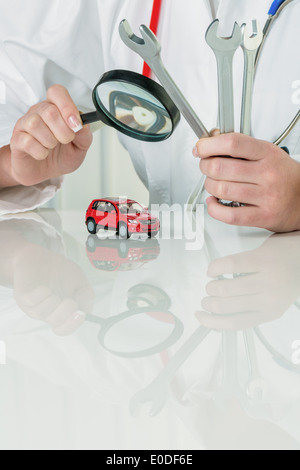 Car is examined by doctor. Costs for servicing and Reperatur, Auto wird von Arzt untersucht. Kosten fuer Wartung und Reperatur Stock Photo