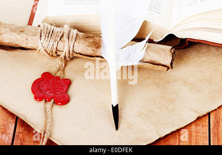 quill pen scroll and parchment on wooden background Stock Photo