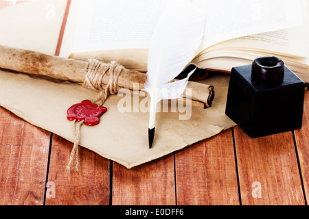 quill pen scroll and inkwell on wooden background Stock Photo