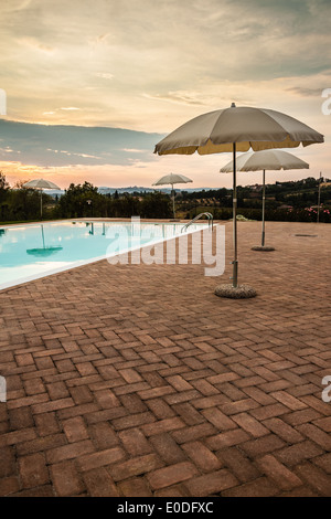 some luxurious parasols on the poolside at dusk Stock Photo