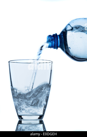 Water is poured from a water bottle in a glass, Aus einer Wasserflasche wird Wasser in ein Glas gegossen Stock Photo