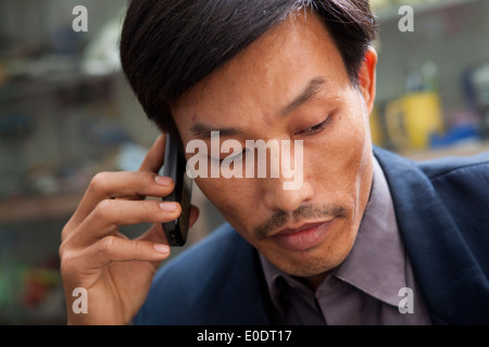 Chatting on a mobile in Hanoi, Vietnam. Stock Photo